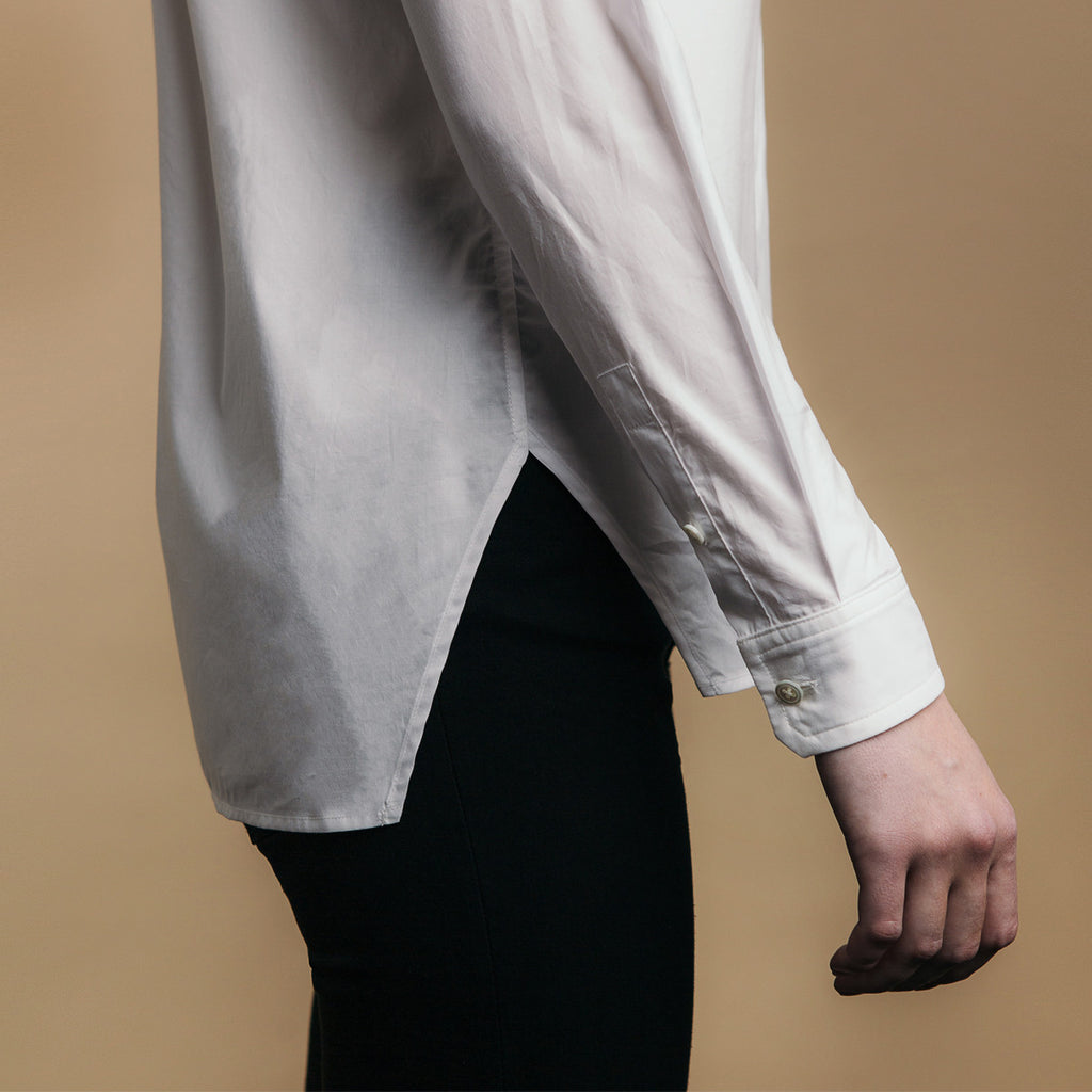 The Trapezoid Shirt - Paper White. Side view, angled hem meets at point.